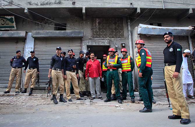 Policemen and rescue workers gather outside a building where unidentified gunmen killed police cadets. ? Photo by Reuters