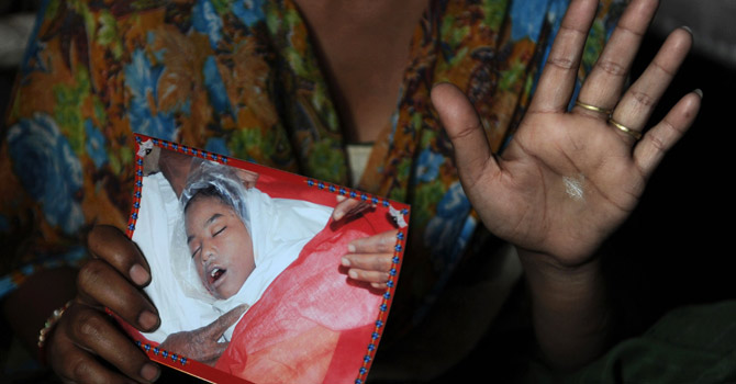 of-her-daughter670 The mother of an 11-year-old girl who died in a New Delhi children's home in December 2011 and was later found to have been sexually abused, holding a picture of her daughter.—AFP Photo