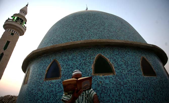 A Palestinian reads from the Quran during the dawn prayer on the first day of Ramazan at a mosque in the West Bank city of Jenin. ? Photo by AP