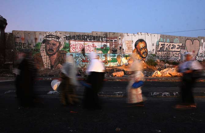 Palestinian women walk towards the Israeli checkpoint of Qalandia near the West Bank city of Ramallah before crossing it on their way to Jerusalem to attend the first Friday prayers of Ramazan at the Al-Aqsa mosque compound. ? Photo by AFP