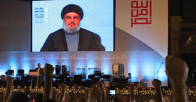 LEBANON-POLITICS-HEZBOLLAH Lebanese Hezbollah supporters raise their fists as they listen to a televised speech by Hezbollah chief Hassan Nasrallah to mark the sixth anniversary of the 2006 war with Israel in southern Beirut on July 18, 2012. AFP