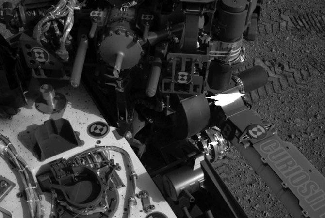 This image released by NASA shows tracks (Upper-R) made by Curiosity's tires during its first test drive as seen by Navcam: Left A (NAV_LEFT_A) on board NASA's Mars rover Curiosity on Sol 16, August 22, 2012.