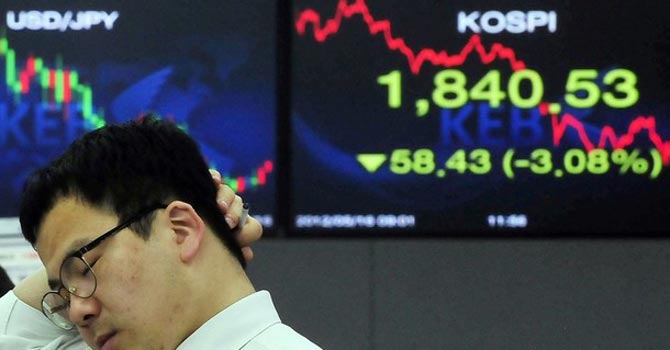 A-currency-dealer-works-in-front-of-an-electronic-board-displaying-the-local-stock-price-index-at-a-dealing-room670 A currency dealer works in front of an electronic board displaying the local stock price index at a dealing room. — Reuters Photo