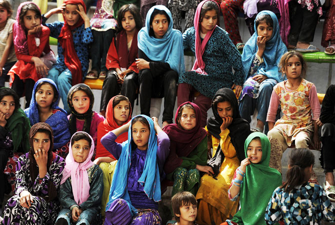Young female Afghan audience members watch a performance.