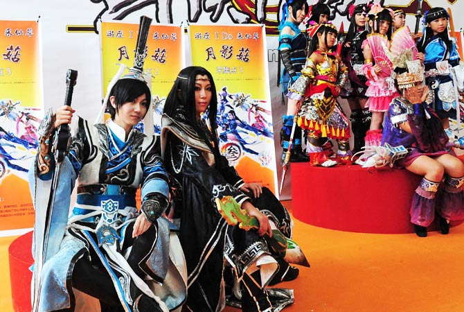 Two groups of cosplayers pose for their photos. - Photo by AFP