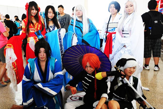 A group of cosplayers pose, all dressed as characters from the same anime. - Photo by AFP