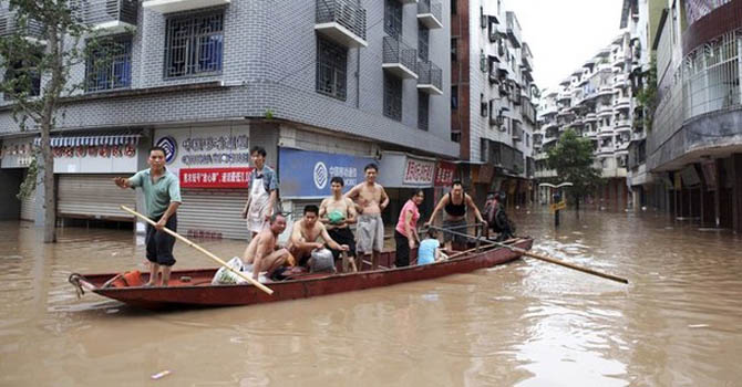 Rescuers row a boat carrying residents to a safer area along a flooded street in Yongchuan district, Chongqing