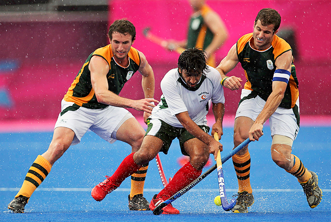 Pakistan's Waseem Ahmad (C) is tackled by South African players.