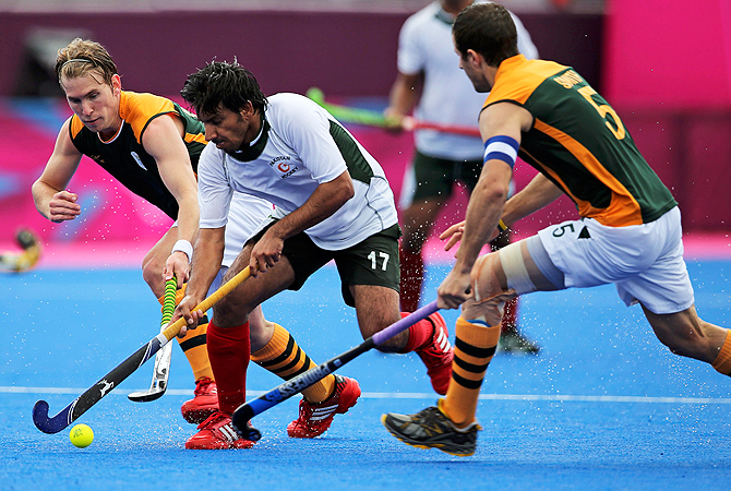 Waseem Ahmad is tackled by South Africa's players.