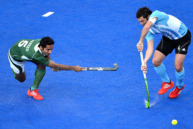 Pakistan's Fareed Ahmed (L) plays a shot against Argentina's Matias Damian Vila. -Photo by AFP