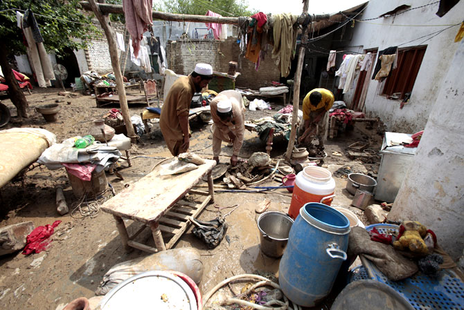 Residents collect their belongings withered by flooding.