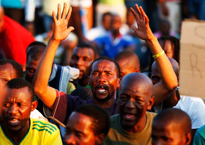Platinum mineworkers react as they listen to a report back on negotiations at Lonmin's Marikana. – Photo by Reuters