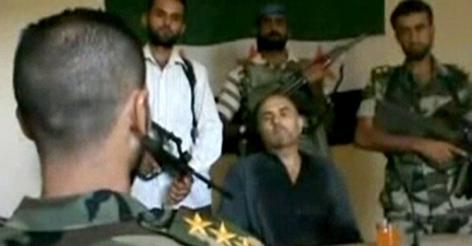 Four armed rebels and a man described in the video as a captured pilot are seen in this still image taken from amateur video out of Syria