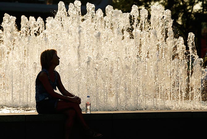 A tennis fan sits in front of a fountain at the National Tennis Centre at the U.S. Open tennis tournament in New York. -Photo by Reuters