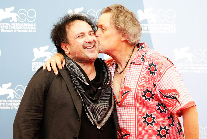 US Director Jonathan Demme (R) kisses Italian singer Enzo Avitabile as they pose during a photocall for the movie “Enzo Avitabile Music Life” at the festival.