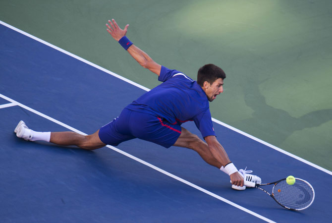 Novak Djokovic of Serbia stretches for a return to Andy Murray of Great Britain during their men's singles final match at the 2012 US Open.