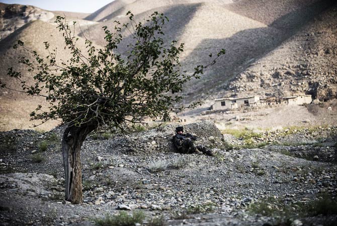 A French soldier secures a perimeter before a convoy's passage. ? Photo by AFP