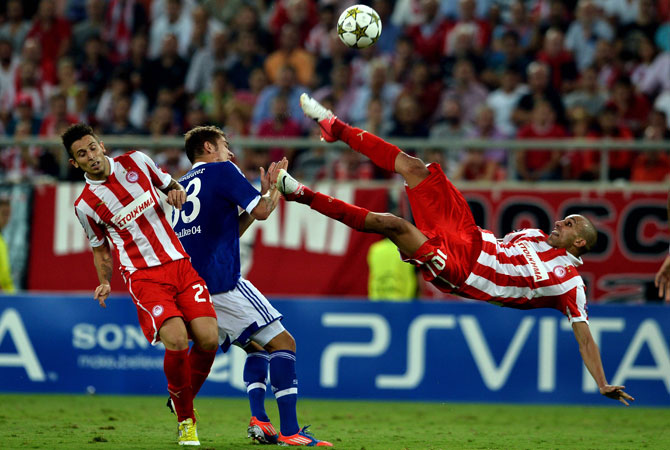Olympiakos' Rafik Djebour (Right) shoots the ball during a group B Champions League football match against Schalke at the Karaiskaki stadium in Piraeus. ? Photo by AFP