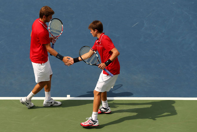 Ryan (Left) and Christian Harrison of the United States tap hands during their men's doubles third round match against Colin Fleming and Ross Hutchins of Great Britain on Day Seven of the 2012 US Open.