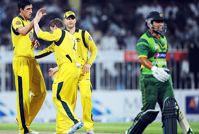 Australia players celebrate taking the wicket of Kamran Akmal. -Photo by AFP