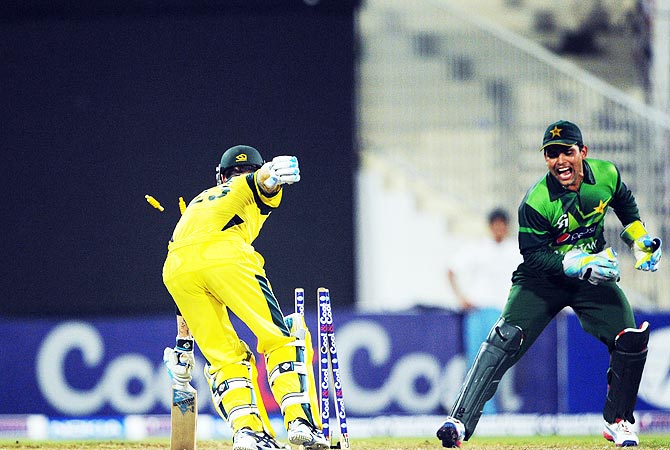 Kamran Akmal (R) celebrates after stumping out Australia's captain Michael Clarke. -Photo by AFP