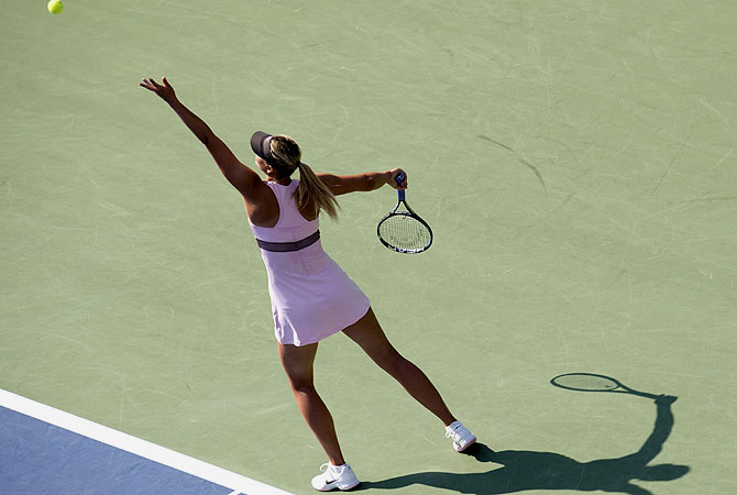 Maria Sharapova of Russia serves to Victoria Azarenka of Belarus during their women's singles semifinal match. -Photo by AFP