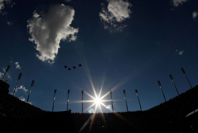 US Air Force F15e Strike Eagles fly over Arthur Ashe Stadium as members of the military unfurl the national flag before the start of the women's singles final match between Serena Williams of the United States and Victoria Azarenka of Belarus on Day Fourteen of the 2012 U.S. Open.