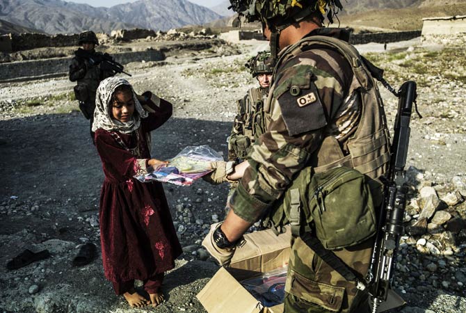 A French soldier gives an Afghan child a kite made by a French student association from Clermont Ferran. ? Photo by AFP
