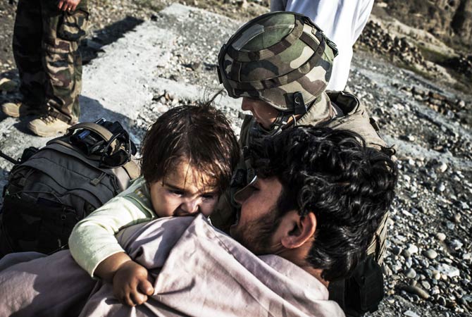 An Afghan child is treated by a French army medic. ? Photo by AFP