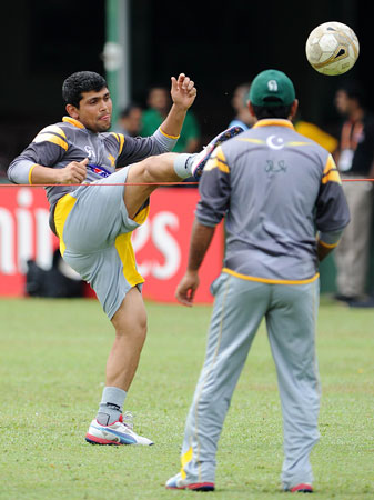 Pakistan cricketer Kamran Akmal (Left) plays football during an ICC Twenty20 Cricket World Cup practice session at the P. Sara Oval Cricket Stadium. ? Photo by AFP