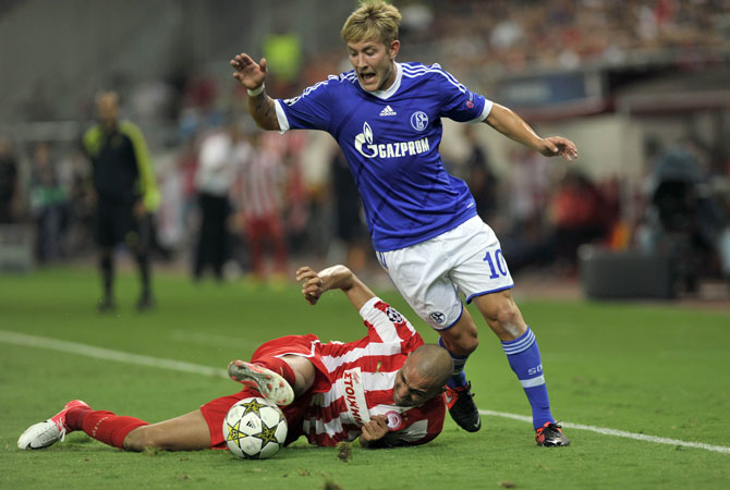 Schalke's midfielder Lewis Holtby vies Olympiakos Rafik Djebbour (Left) during their group B Champions league. ? Photo by AFP