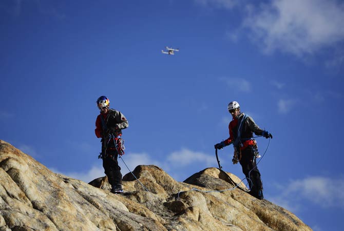 Mammut, Peter Ortner and David Lama walk on the Trango Summit in northern Pakistan's Karakoram mountain range while a remote-controlled helicopter flies over them. ? Photo by AP