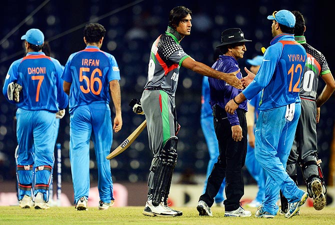 Afghanistan's Shapoor Zadran (C) shakes hands with India's players after the match. -Photo by Reuters