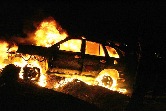 Vehicles burn after armed Libyan demonstrators stormed the headquarters of the Raf Allah al-Sahati Brigade, a local militia, located at a farm in the Hawari region 15 kilometres (10 miles) from the centre of Benghazi.