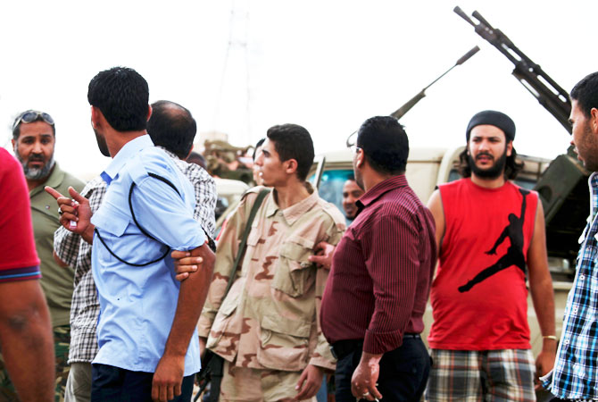 Members of the Rafallah Sahati Islamic Militia Brigades, argue with a Libyan policemen, second left, regarding a request for the militia to evacuate their base.