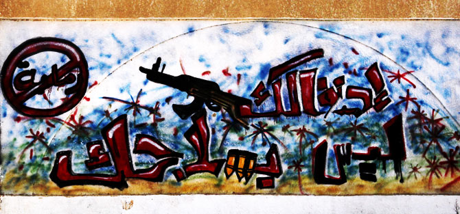 Graffiti on one of the city walls calls on people to stop random and celebratory firing of weapons. Arabic writing reads ?celebrate.. but not with your gun.?