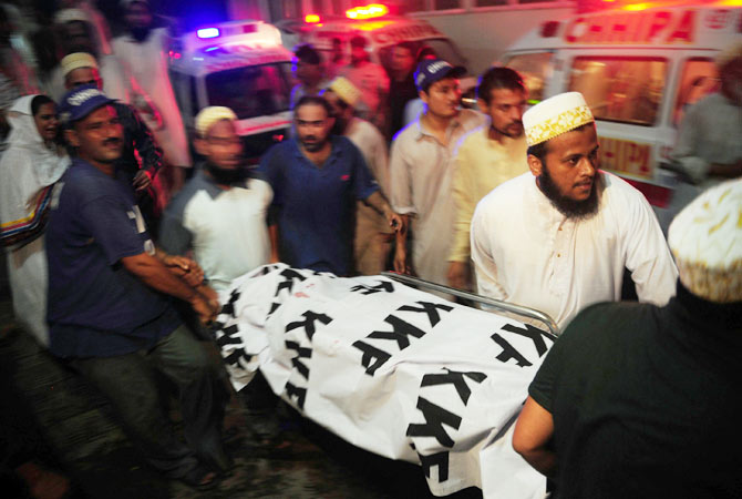 People carry the body of a blast victim to a hospital.