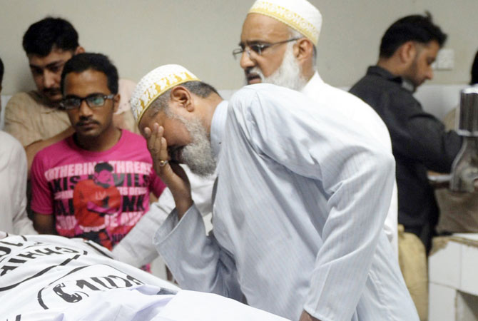 A man moruns near the body of a blast victim.