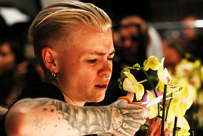 A hair dresser clips orchids to be used as head pieces backstage at the Issa Spring/Summer 2013 collection at London Fashion Week.– Reuters Photo