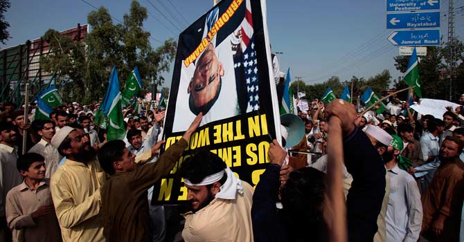 karachi-protest-anti-islam-film-ap-670 Angry protesters strike a poster showing a portrait of US President Barack Obama during a demonstration against the anti-Islam film. – Photo by AP