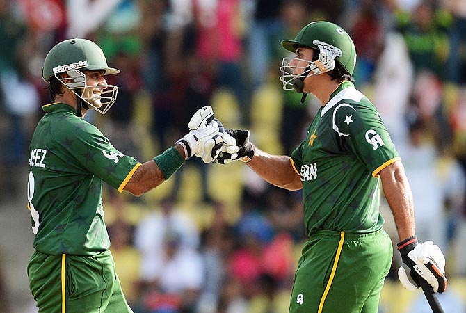 Mohammad Hafeez (L) congratulates Nasir Jamshed for scoring a half century. -Photo by AFP