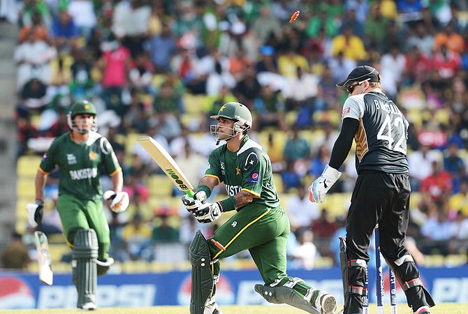 A bail flies up as Pakistan cricket captain Mohammad Hafeez (C) is clean bowled by New Zealand bowler James Franklin. -Photo by AFP