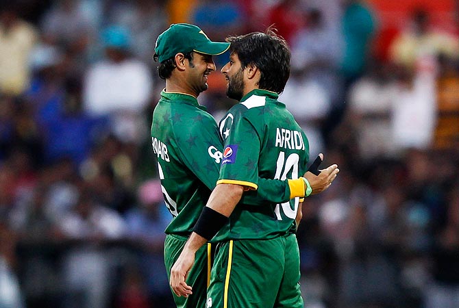 Pakistan's Shahid Afridi (R) is congratulated by Shoaib Malik after he took the wicket of New Zealand's Rob Nicol. -Photo by Reuters