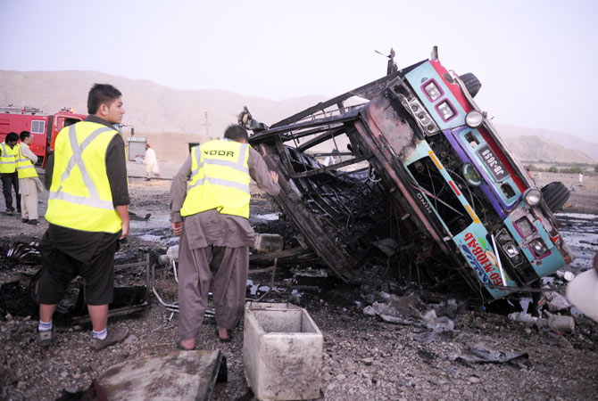 Volunteers search for blast victims in the wreckage of the destroyed passenger bus.