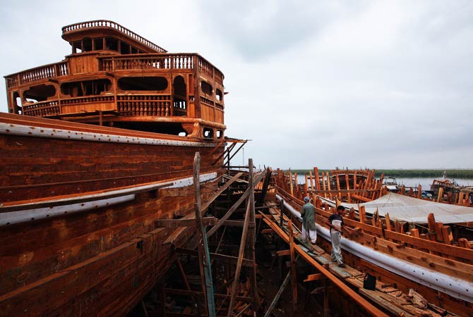 Labourers work on a portion of a boat in a shipyard in Karachi's Fish Harbor. The yard is used mainly for building and repairing cargo and fishing boats. ? Photo by Reuters