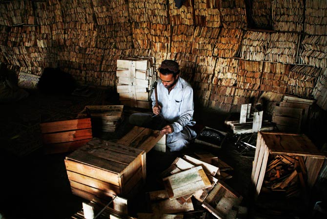 A labourer mixes water and sand that will later be moulded into bricks by his family takes a break from his chores. ? Photo by AFP
