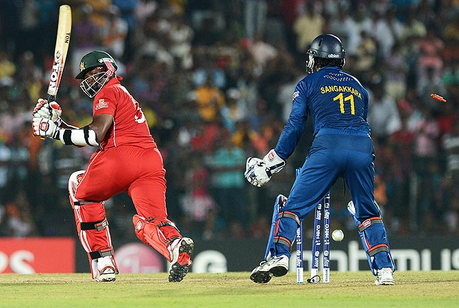 Zimbabwe's cricketer Hamilton Masakadza (L) is bowled out by Sri Lankan cricketer Ajantha Mendis. -Photo by AFP