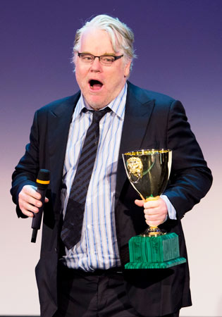 Actor Philip Seymour Hoffman reacts after being awarded the Coppa Volpi with Joaquim Phoenix (not shown) for best actor for their role in the film 'The Master'.