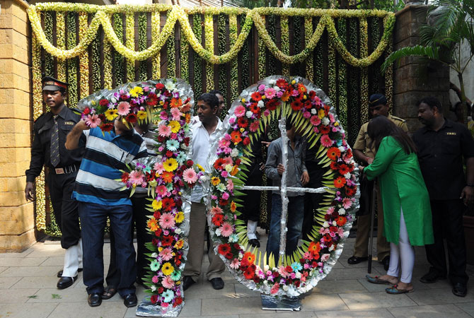 Indian security guards inspect a floral arrangement in the shape of the number seventy at the entrance of Bollywood actor Amitabh Bachchan residence on his 70th birthday in Mumbai on October 11, 2012. ? Photo by AFP