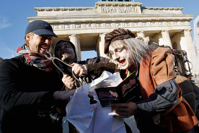 Actors in costumes perform as they promote the ?Berlin Dungeon? in front of the Brandenburg Gate in downtown Berlin on October 26, 2012. ? Photo by Reuters